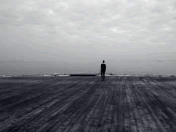 Silhouette man standing on beach against sky