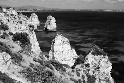 Rocks on sea shore against sky