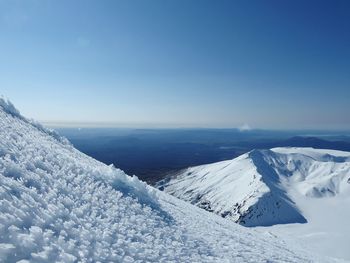 Scenic view of snowcapped mountains against blue sky