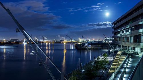 Illuminated dock against sky at night in moonlight