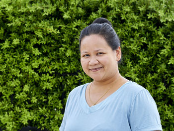 Portrait of smiling woman against trees