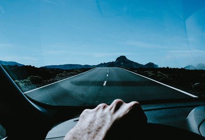 Midsection of man driving car against sky