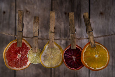 Close-up of dried fruit slices hanging on rope against wooden wall