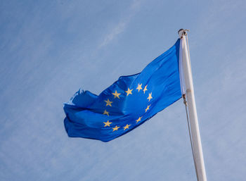 Low angle view of flag against blue sky