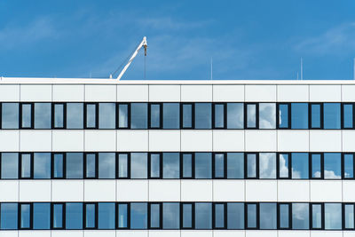 Low angle view of modern building against blue sky