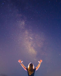 Rear view of woman standing against star field