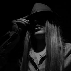 Low angle view of women with long hair wearing hat in darkroom