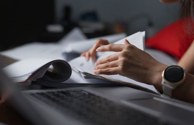 Midsection of woman using laptop on table