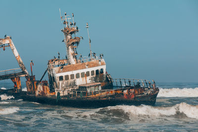 Ship sailing in sea against clear sky