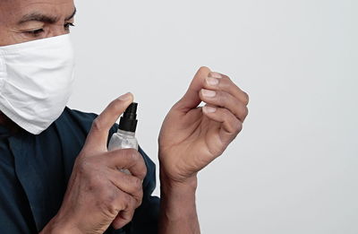 Midsection of man holding hands against white background