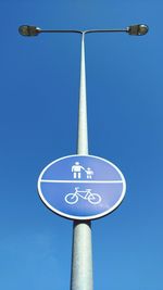 Low angle view of road sign against blue sky