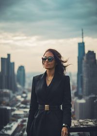 Portrait of young woman standing against sky during sunset