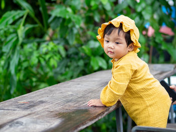 Portrait of young woman sitting on wood