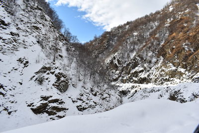 Snow covered land and mountains against sky