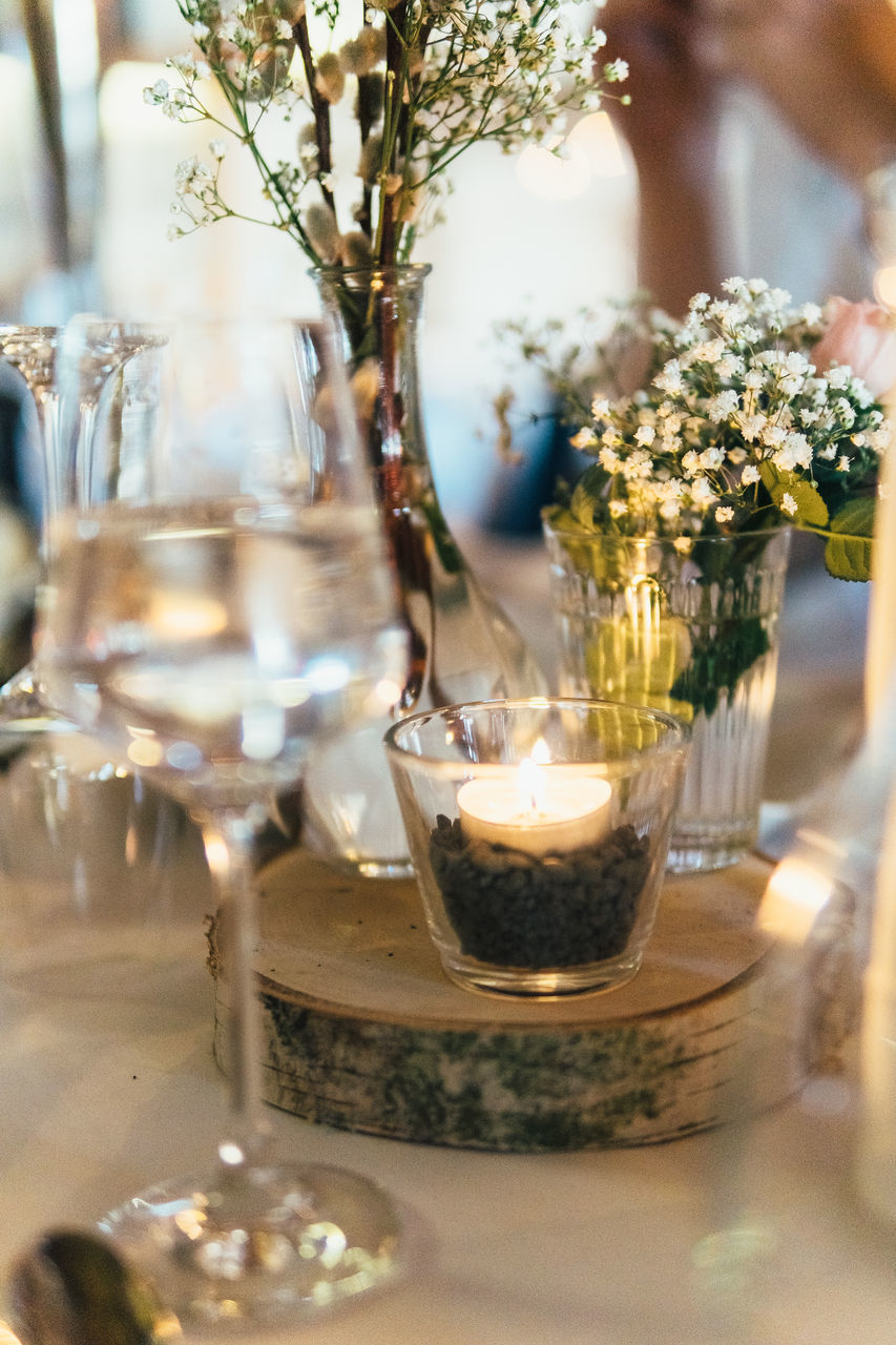 CLOSE-UP OF FLOWER POT ON TABLE AGAINST GLASS