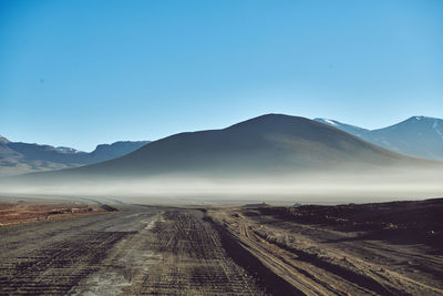 Scenic view of mountains against clear blue sky