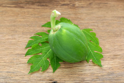 Papaya with leaves on old wood floor.