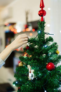 Cropped image woman decorating christmas tree