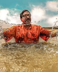 Full length portrait of man on water against sky