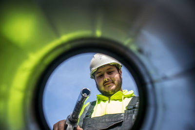 Low angle view of young man feeling petrol