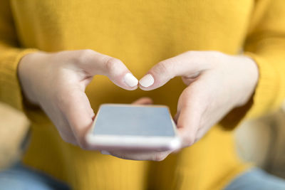 Midsection of woman holding mobile phone