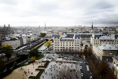High angle view of city buildings against cloudy sky