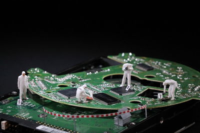 Close-up of figurines working on circuit board