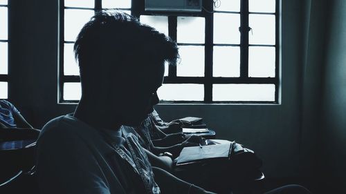 Close-up of man looking through window