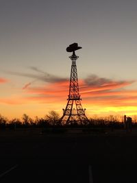 Replica eiffel tower on field against sky during sunset