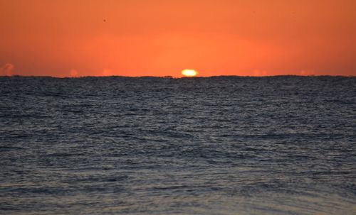 Scenic view of sea against orange sky