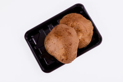 High angle view of bread in plate against white background