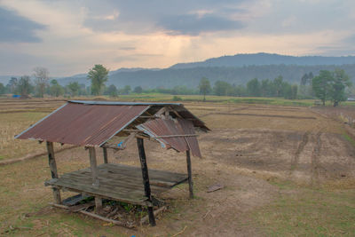 Lifeguard hut on field against sky during sunset