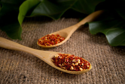 High angle view of dried chili in wooden spoons on burlap