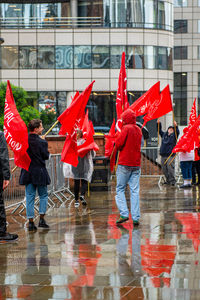 Reflection of people on wet umbrella in city during rainy season