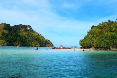 People enjoying at beach against sky at krabi