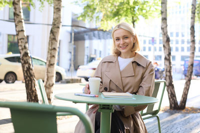 Portrait of young woman sitting on swing