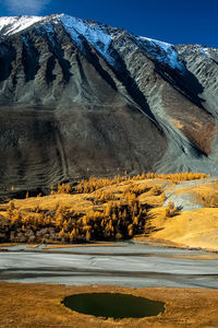 Road by snowcapped mountains against sky