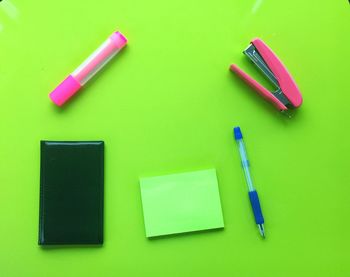 Directly above shot of office supply on green background