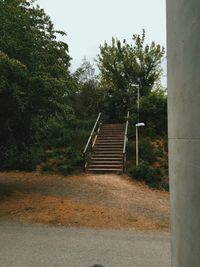 Staircase by trees against sky