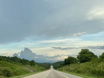 Road by trees against sky