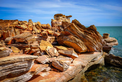 Rock formations in sea against sky