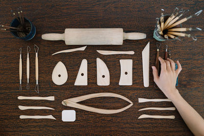 Cropped hand arranging hand tools on wooden table