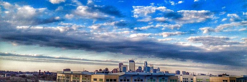 Buildings in city against cloudy sky