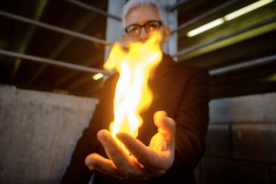 Portrait of man holding burning fire