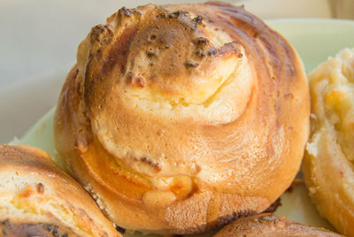 Freshly baked cinnamon rolls with icing on a plate. close-up, sweet homemade christmas pastries.