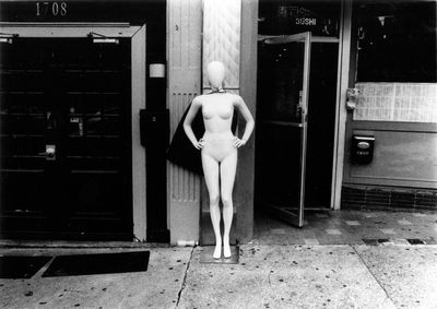 Woman standing by door in city