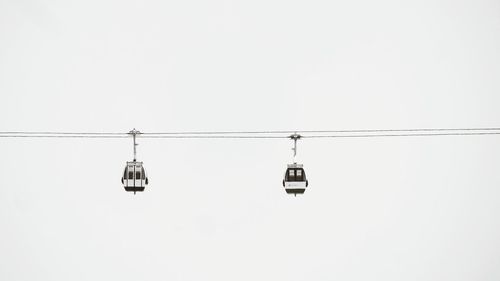 Low angle view of ski lifts against clear sky