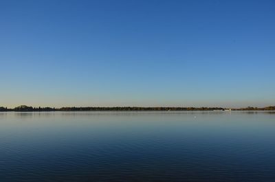 Scenic view of lake against clear blue sky