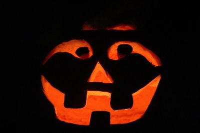 Close-up of illuminated halloween pumpkin against black background