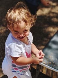 High angle view of cute baby girl standing outdoors